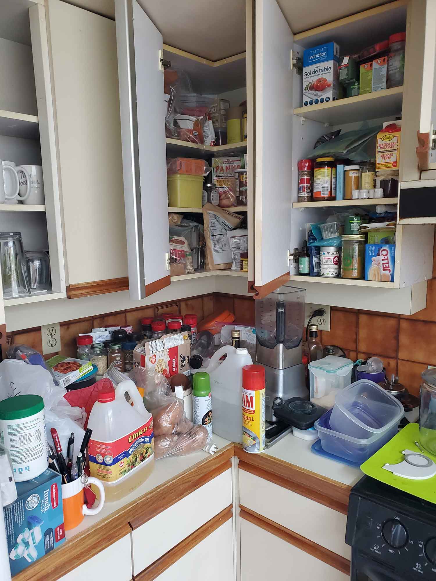 A kitchen with full shelves and a counter-top inaccessible due to items stack on it